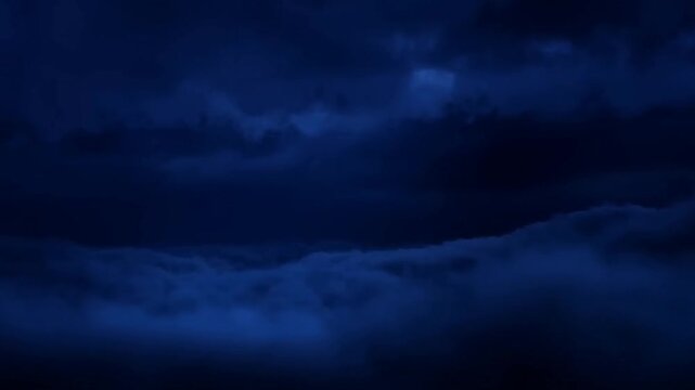 Dramatic thunderstorm with flashes illuminating dark night sky and rolling clouds