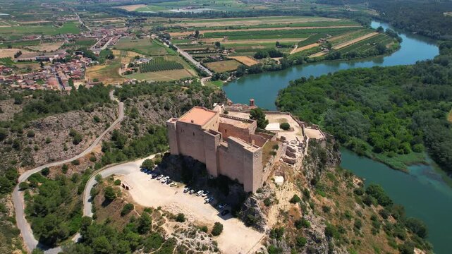 Panoramic circular drone shot of Miravet's castle, Spain&mdash;Old Templars' castle taken from above, featuring its river, forest, and medieval town. 