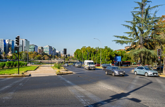 Santiago, Chile, April 15, 2026, Traffic at a busy intersection in the Providencia district with cars, buildings, and trees under a clear blue sky