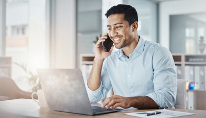 Obraz premium Smiling man talking on mobile phone while working at modern office desk