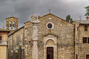 Naklejka premium Alte Steinfassade der Kirche Sant'Egidio mit der Wölfin-Säule in Montalcino, Toskana, Italien / Stone facade of Sant'Egidio church with she-wolf column in Montalcino, Tuscany, Italy