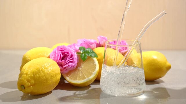 Pure water is poured into a glass, and the concept of fresh water with lemon and rose flavors is presented