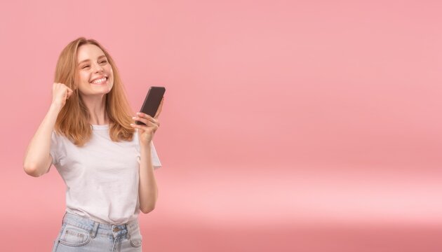 Cheerful young woman using smartphone with a bright smile on pink background
