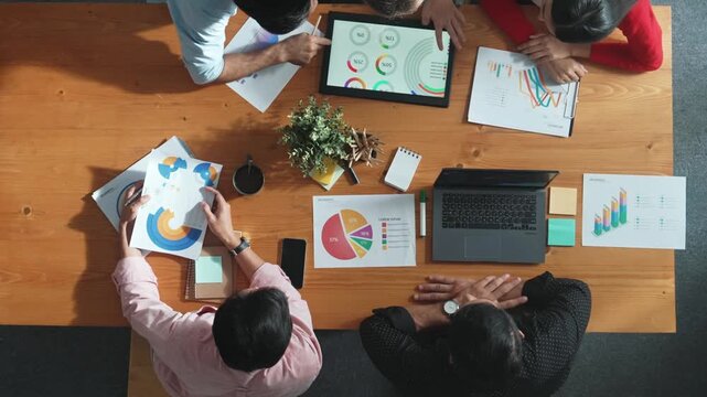 Top down view of business woman explain and present financial chart. Diverse group discuss and listen presentation about stock market statistic at meeting table with investment graph. Convocation.
