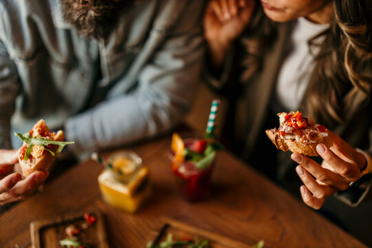 Couple enjoying bruschetta appetizers and cocktails at restaurant
