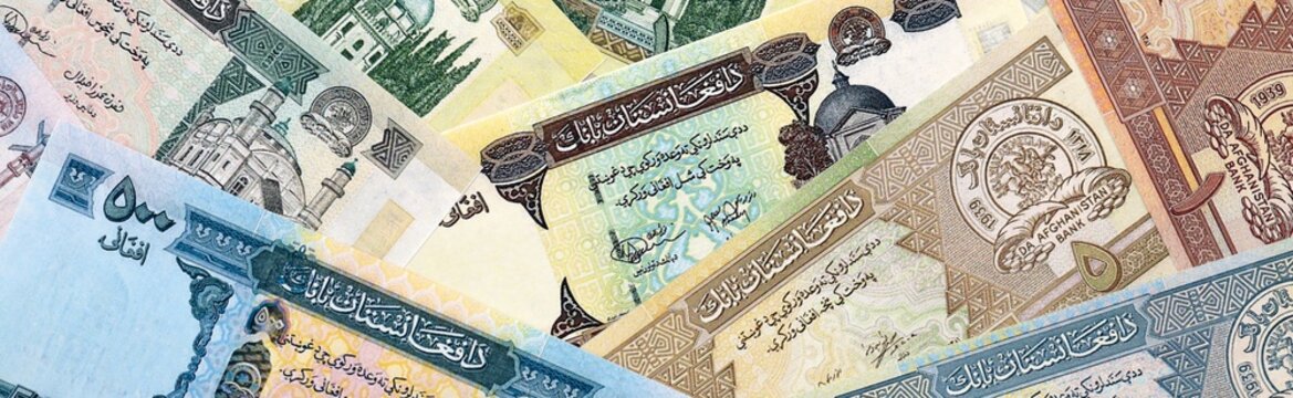 Afghan afghani money bills in pile on table. Afghanistan AFN currency cash close up