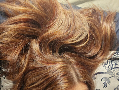 Close up of long wavy brown hair with blonde highlights texture