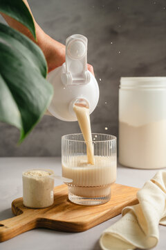 Protein supplement drink being poured from shaker into glass