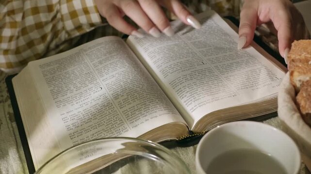 young conservative asian Woman Reading the Bible at table with bread food and drink indoors