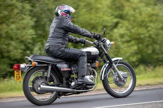 Stony Stratford,Bucks,UK - June 7th 2026:  Man riding a  1974 Triumph Trident classic  motorcycle driving on a British road