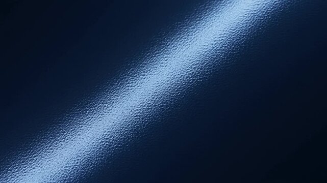 Slow tracking shot of light reflection sliding across rippled dark blue water surface closeup slow motion pan revealing diagonal glossy texture