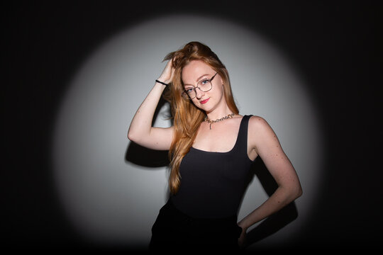 fotografia em est&uacute;dio, editorial de moda, modelo branca com cabelos ruivos longos, roupa preta, pose moderna com est&eacute;tica dram&aacute;tica ilumina&ccedil;&atilde;o focal com sombras marcadas