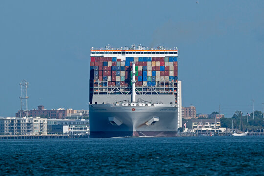 The bow of the cargo ship OOCL Sunflower, showing stacked shipping containers, as it departs Charleston Harbor, SC, USA on June 11, 2026.