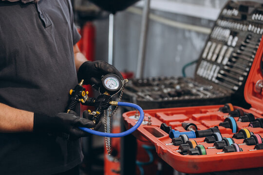 Mechanic holding car cooling system pressure tester