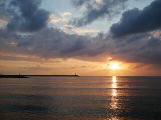 Obraz premium Dramatic Sunset Over Calm Sea with Golden Reflection on Water