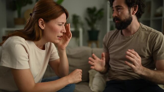 Frustrated couple arguing and fighting on the sofa at home, leading to crying and relationship problems