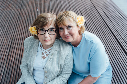 Elegant Senior Women Sitting Together With Flowers Showing Friendship And Trust