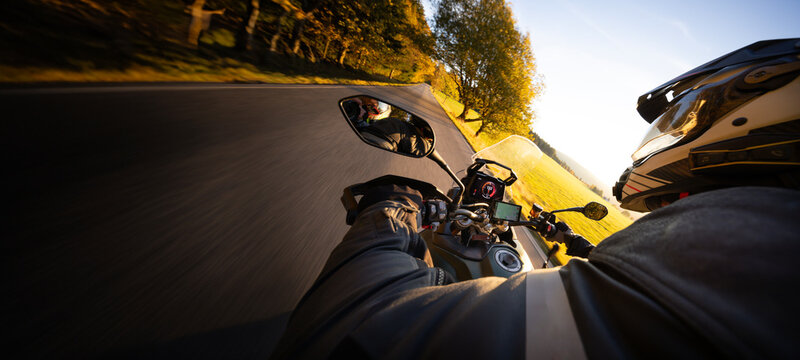 Driver riding motorcycle on empty road