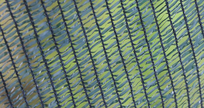 Close up of green plastic safety net swaying in the wind