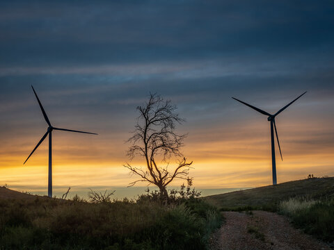 Sunset with wind turbines on a mountain.in