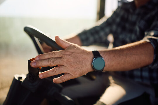Close up of farm worker driving tractor.