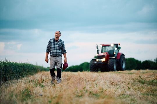Full length of mature farmer walking in field.