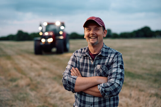 Confident farm worker in agricultural field during harvest season and looking at camera.