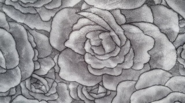 Cozy winter lifestyle b roll of gray fleece blanket with embossed rose pattern texture, soft monochrome fabric background for aesthetic video.