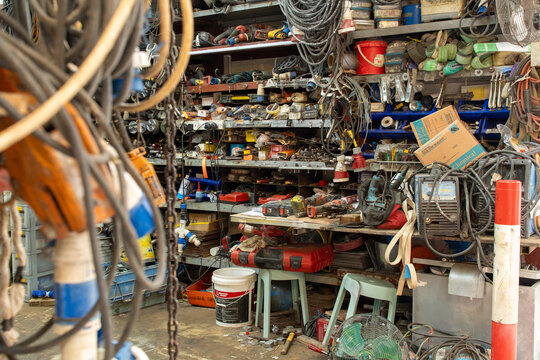 Cluttered workshop with electrical tools cables and equipment in organized industrial storage space