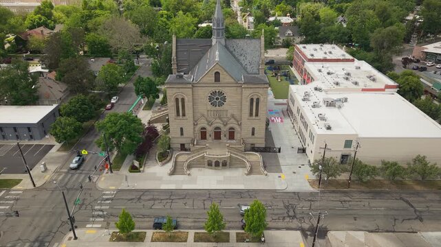 Slow high altitude pushing drone shot of the Cathedral of St. John the Evangelist in downtown Boise, Idaho, during spring. Smooth forward movement reveals the historic church and surroundings.