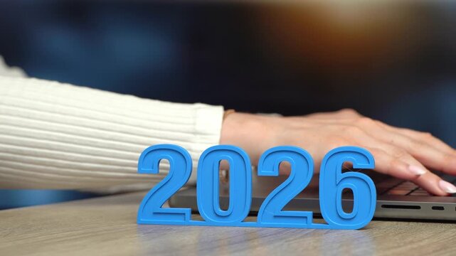The year is 2026 and a woman is working on a laptop in the background. Business plans and economic forecasts. Strategic vision, market expectations and financial planning. Corporate strategy content