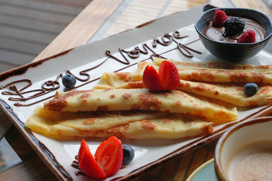 Platter of fruit and chocolate crepes saying Bon Voyage in melted chocolate