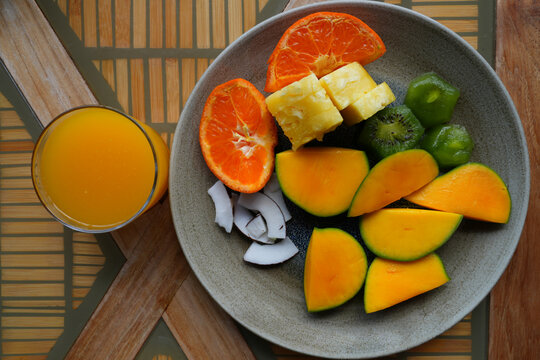 View of a healthy tropical fruit platter with pineapple, clementine, kiwi, and mango
