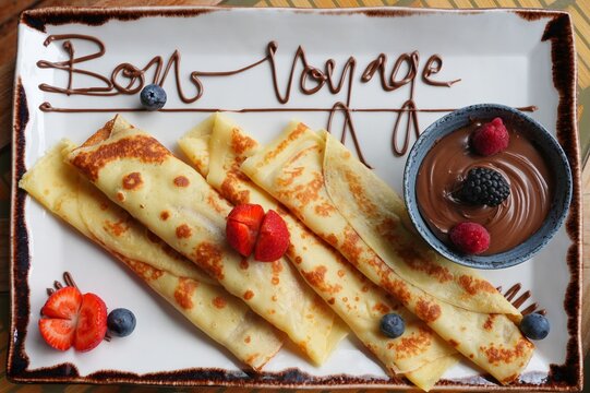 Platter of fruit and chocolate crepes saying Bon Voyage in melted chocolate