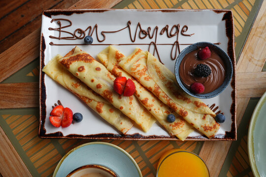 Platter of fruit and chocolate crepes saying Bon Voyage in melted chocolate