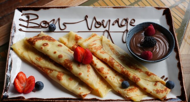 Platter of fruit and chocolate crepes saying Bon Voyage in melted chocolate