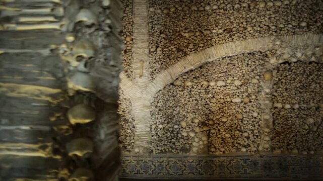 Evora, Portugal - August 18, 2017: dried corpse inside the Chapel of Bones or Capela dos Ossos, one of the most visited monuments of Evora. Walls and columns adorned with human bones and skulls.