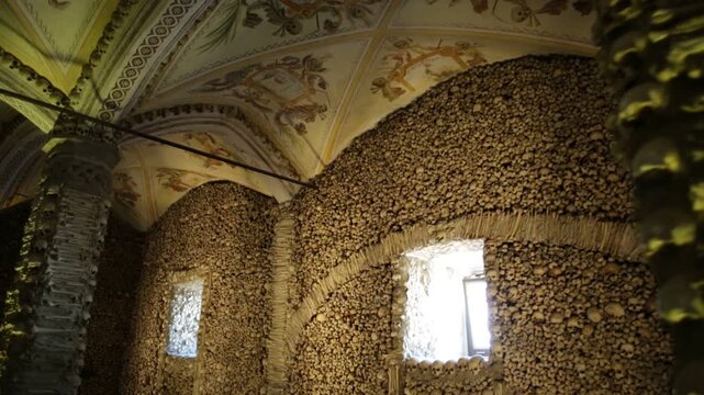 Evora, Portugal - August 18, 2017: Chapel of Bones or Capela dos Ossos, one of most visited monuments of Evora. Walls and columns adorned with human bones and skulls. Mortuary-themed painted ceiling.