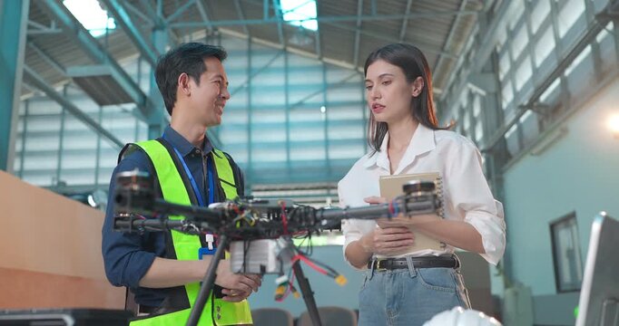 Startup Entrepreneur and Engineer Review Drone Prototype in Industrial Workshop