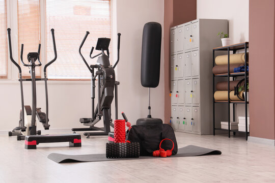 Home gym interior with elliptical trainers, punching bag, and fitness equipment for health and wellness