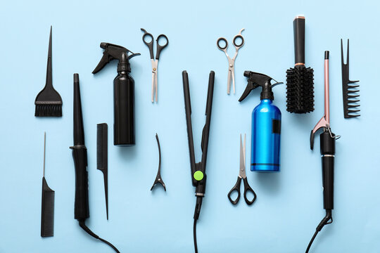 Professional hairdressing tools and styling equipment for salon or home use on a light blue background