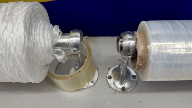 Transparent film white rope on counter showcasing closeup of dispenser with clear stretch film and dense white twine spool ready