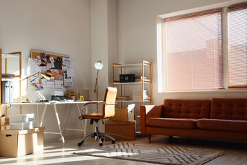 Fototapeta premium Detectives office with investigation board, typewriter, and leather sofa in sunny room