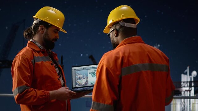 Offshore platform men use map on device to circumvent petrol extraction blockade while african american expert and drilling rig colleague search for alternate maritime routes during oil crisis.