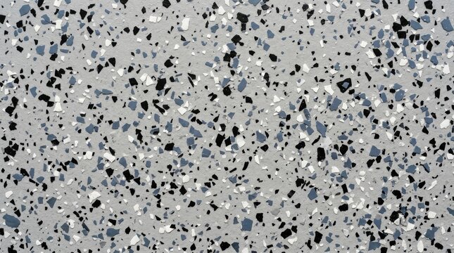 Textured epoxy resin floor surface featuring scattered black white and blue decorative flakes providing a modern durable industrial flooring finish