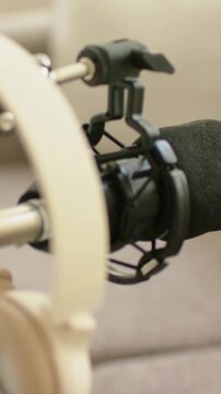 Vertical video: Pulling focus camera shifting right at home studio, revealing mic foam, shock mount