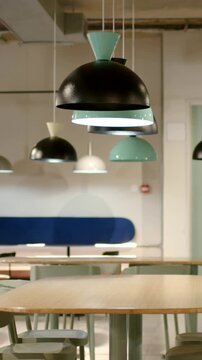 Vertical video: Panning camera capturing pendant lamps in lounge, highlighting black turquoise dome