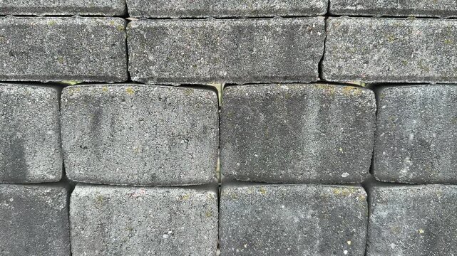 Top view paving stone samples display, close-up texture of coarse concrete pavers arranged on retail stand, neutral tan and gray