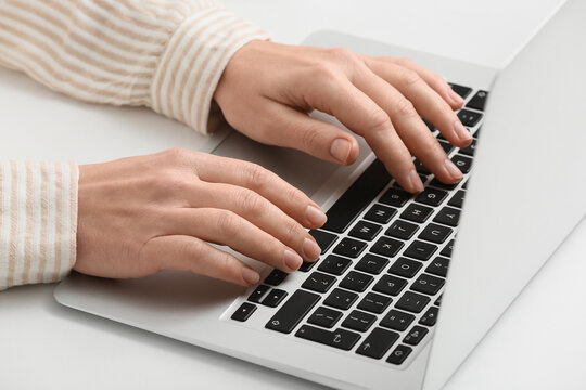 Young female programmer with laptop working in office, closeup