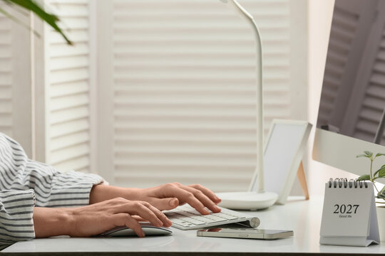 Young female programmer with computer typing on keyboard in office, closeup